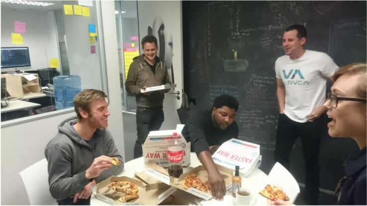 The Afrolabs team celebrating with Brad over pizza